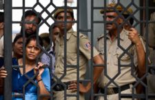 Indian court staff and policemen watch demonstrators shout slogans following the sentencing of four men convicted of rape and murder at the Saket courthouse in New Delhi on September 13, 2013. A judge sentenced four men to death September 13 for the fatal gang rape of an Indian student on a bus last December, triggering applause inside the packed courtroom. AFP PHOTO/MANAN VATSYAYANA        (Photo credit should read MANAN VATSYAYANA/AFP/Getty Images)