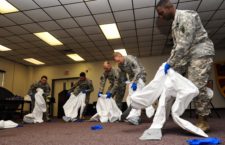 U.S. Army Soldiers from the 53rd Transportation Battalion (Movement Control), 7th Transportation Brigade (Expeditionary), learn how to don personal protective equipment at Fort Eustis, Va., Oct. 15, 2014. Although Fort Eustis personnel deploying to West Africa will not treat Ebola-infected patients, they were provided specialized training on use of PPE in the events of potential exposure. (U.S. Air Force photo by Airman 1st Class Breonna Veal) (This photo was cropped, contrasted and sharpened to emphasize the subjects.)